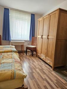 ein Schlafzimmer mit einem Bett, einem Schrank und einem Tisch in der Unterkunft Ferienhaus Wellsandt in Norderney