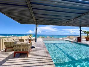 a swimming pool with chairs and a large umbrella at Centric condo by Casago in Playa del Carmen