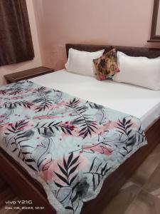 a bed with a comforter and pillows on it at Hotel vikram in Khajurāho