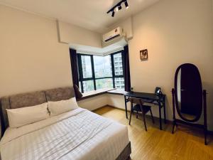 1 dormitorio con cama, escritorio y ventana en Timber Lounge - 2BR Pool View Forest Haven - Dryer - Netflix, en Johor Bahru