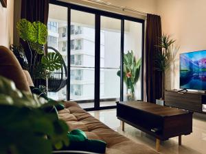 sala de estar con sofá y TV en Timber Lounge - 2BR Pool View Forest Haven - Dryer - Netflix, en Johor Bahru