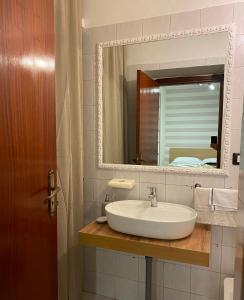 a bathroom with a sink and a mirror at LULU' LESUITES in Cava deʼ Tirreni