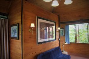 sala de estar con sofá azul y 2 ventanas en Zen Cafe Countryside Retreat 