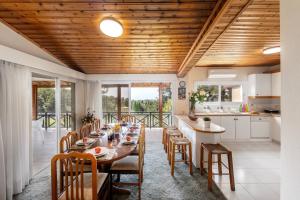cocina y comedor con mesa larga y sillas en Platres Forest Panorama Cottage, en Platres