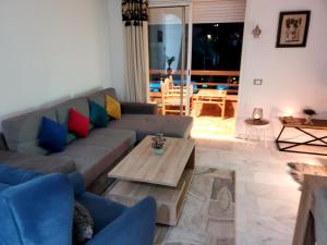 - un salon avec un canapé et une table dans l'établissement Stylish & homely 3 fresh beds & pool view, à Marrakech