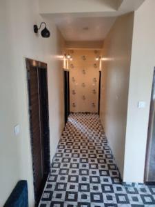 einen Flur mit schwarzweißem Fliesenboden in der Unterkunft Hotel Shivalay Palace,Maheshwar in Maheshwar