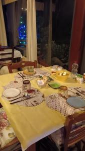 a table with a yellow table cloth with a christmas tree at Le Travi in Sarzana