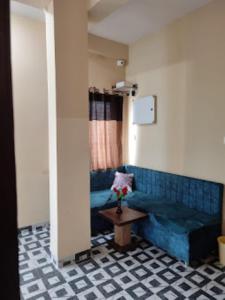 ein Wohnzimmer mit einem blauen Sofa und einem Tisch in der Unterkunft Hotel Shivalay Palace,Maheshwar in Maheshwar