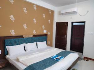Schlafzimmer mit einem großen Bett mit blauem Kopfteil in der Unterkunft Hotel Shivalay Palace,Maheshwar in Maheshwar