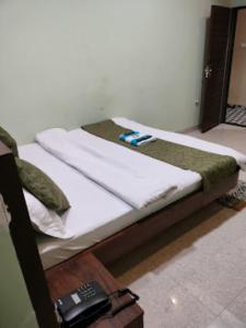 2 Betten in einem Zimmer mit Fernbedienung in der Unterkunft Hotel Shivalay Palace,Maheshwar in Maheshwar