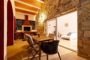 uma sala de jantar com uma parede de pedra e uma mesa e cadeiras em Red House Trget with Swimming Pool, Sauna and Jacuzzi em Labin