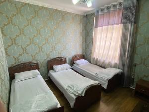 2 camas individuales en una habitación con pared en ANIS HOTEL en Samarcanda