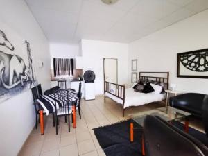 a living room with a bed and a couch at Leather & Lace in Groutfontein