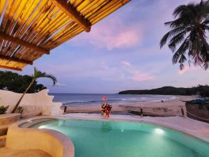 a group of people standing around a swimming pool next to the beach at Santa Fe House - Gành Đá Đĩa in Phú Hạnh (5)