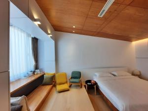 1 dormitorio con 1 cama grande y 2 sillas en 珍遇珍寓電梯民宿 June June House, en Tainan