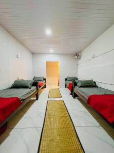 um quarto com três camas e uma porta amarela em The Last Try - Secret Ashram Coorg em Siddapur