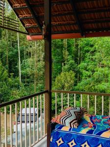 a bed on a porch with a view of the woods at The Last Try - Secret Ashram Coorg in Siddapur