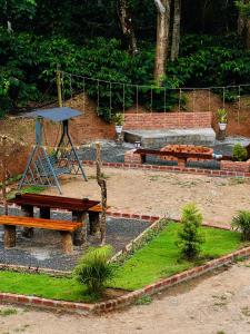 a park with three benches and a picnic table at The Last Try - Secret Ashram Coorg in Siddapur