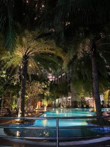 une piscine bordée de palmiers et un bâtiment dans l'établissement Luxury Apartment at Vinhomes Central, à Hô-Chi-Minh-Ville