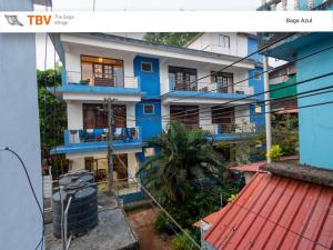 un edificio de apartamentos azul y blanco con balcón en The Baga Village-TBV, en Baga