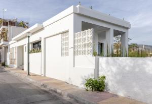 ein weißes Gebäude an der Straßenseite in der Unterkunft Luxury Villa in Center of Agioi Theodoroi in Agii Theodori
