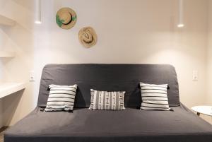 ein Bett mit einem schwarzen Kopfteil mit zwei Kissen in der Unterkunft Luxury Villa in Center of Agioi Theodoroi in Agii Theodori
