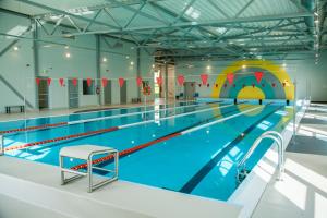 a large indoor swimming pool with a pool slide at Zirgu sēta "Klajumi" - Horse ranch "Klajumi" in Kaplava