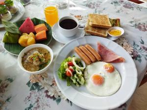 - une table avec une assiette d'aliments avec des œufs et du pain grillé dans l'établissement Suan Bankrut Beach Resort, à Ban Krut