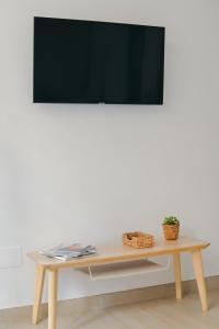 un tavolo con TV su una parete bianca di Larios Premium Apartments a Málaga