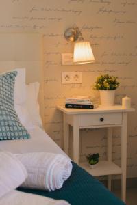 ein Schlafzimmer mit einem Bett und einem Tisch mit einer Lampe in der Unterkunft Larios Premium Apartments in Málaga