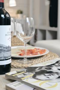 a table with a bottle of wine and a plate of food at Larios Premium Apartments in Málaga