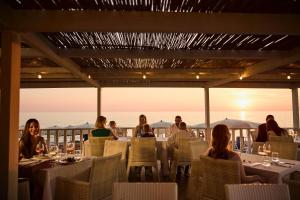 un grupo de personas sentadas en una mesa en un restaurante en ROBINSON APULIA - All Inclusive, en Ugento