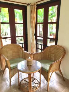 two chairs and a table in a room with windows at Suan Bankrut Beach Resort in Ban Krut