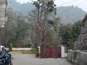 uma moto estacionada em frente a um portão vermelho em Ratan Homestay em Shivpuri