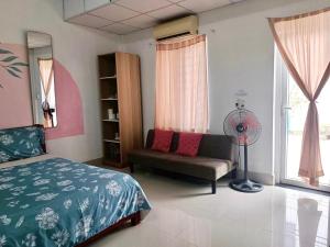een slaapkamer met een bed, een stoel en een ventilator bij Gia Khôi Homestay in Hue