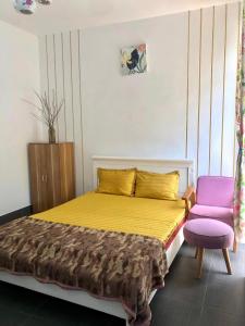 een slaapkamer met een bed en een paarse stoel bij Gia Khôi Homestay in Hue