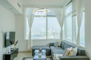 uma sala de estar com um sofá e uma grande janela em Marina Sea & Canal View 1BR Perfectly Cosy em Dubai