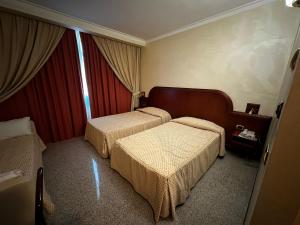 a hotel room with two beds and a window at Grand Hotel Europa in Isernia