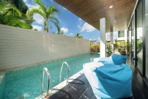 una cama junto a una piscina en 3-Story Pool Villa Katahan UTK B4 just 7 min walk to Kata Beach en Kata Beach