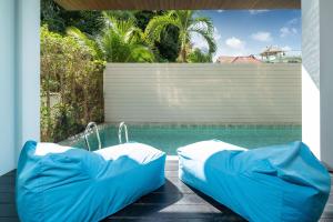 uma piscina com duas camas insufláveis ao lado de uma piscina em 3-Story Pool Villa Katahan UTK B4 just 7 min walk to Kata Beach em Praia de Kata