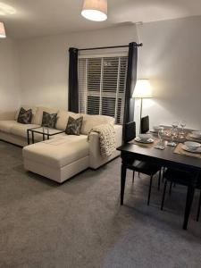 a living room with a couch and a table at 2 bedroom modern flat in Romsey in Romsey
