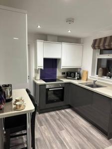 a kitchen with black and white cabinets and a table at 2 bedroom modern flat in Romsey in Romsey