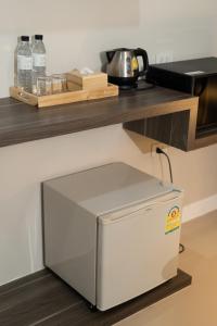 un piccolo frigorifero sotto un bancone in cucina di We Resident Hotel a Hat Yai