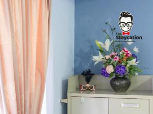 un jarrón de flores encima de un tocador en Staycation Homestay 33 Floridale Condominium near viva city, en Kuching