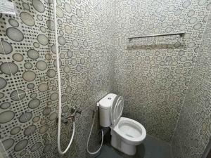 a small bathroom with a toilet in a shower at RedDoorz at Ramelau near AP Pettarani in Makassar +70 photos