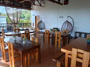 a dining room with wooden tables and chairs at Alec Lodge in Coron