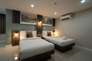 ハジャイにあるWe Resident Hotelのベッド2台が備わる部屋