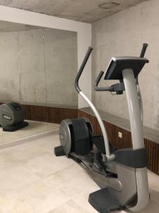 - une salle de sport avec un tapis roulant et un miroir dans l'établissement White Design Apartment, à Aveiro