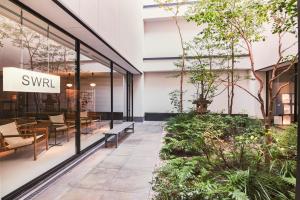 een lobby van een gebouw met banken en planten bij KABIN Taka in Kyoto
