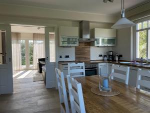 a kitchen with a wooden table and white cabinets at Kapitänshaus Bergmeyer mit Meerblick in Norderney